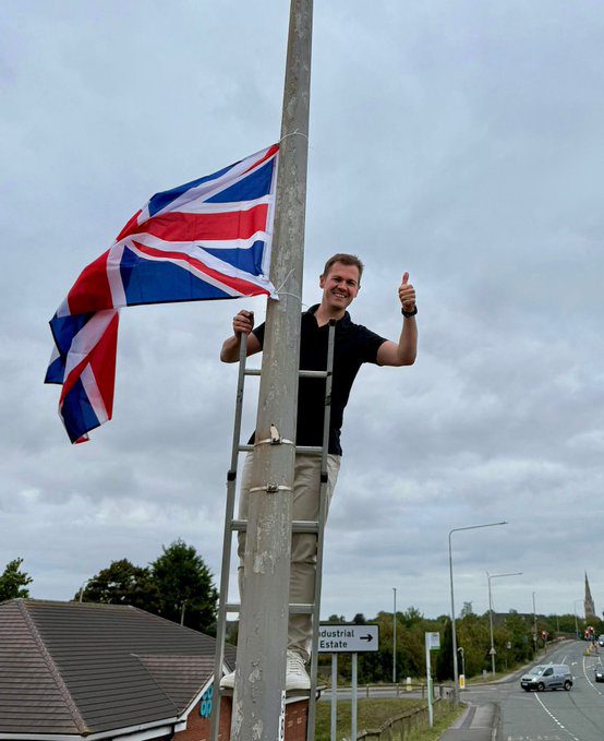 Robert Jenrick participates in operation raise the colours with a union jack flag